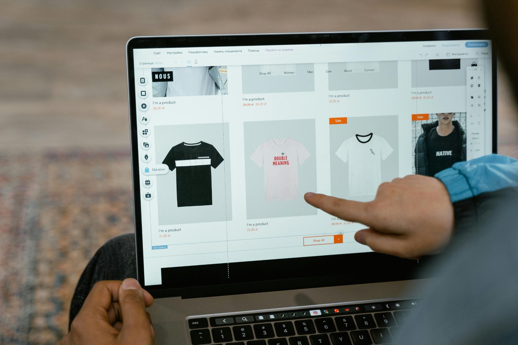 Picture of a person pointing at a t-shirt product listing while learning how to launch a shopify store