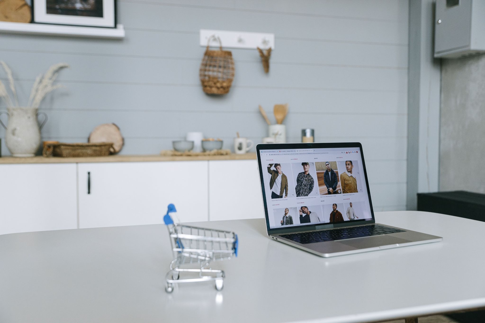 Picture of a miniature shopping cart in front of a laptop