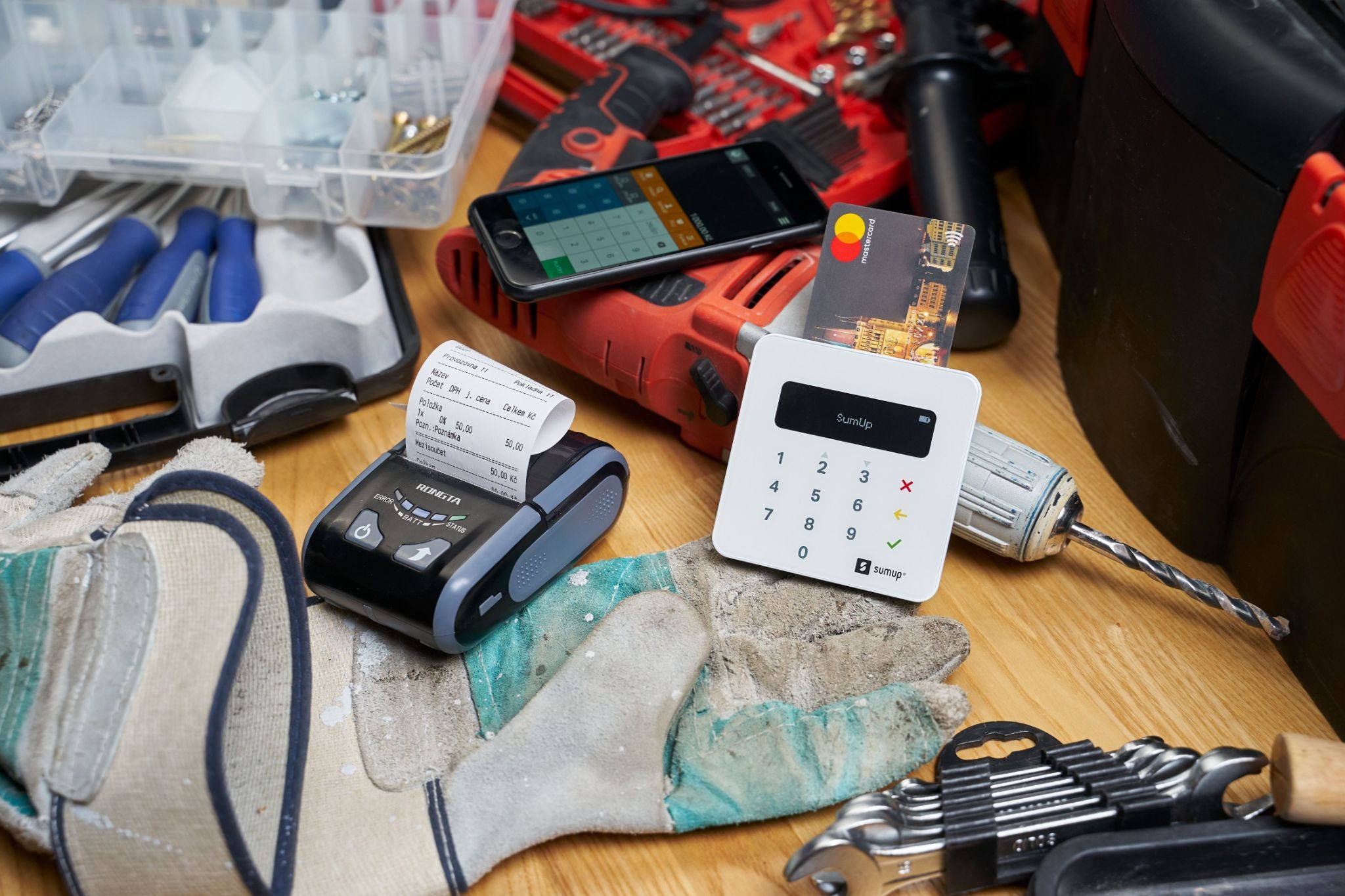 Picture of a card reader and receipt printer on a workbench with tools