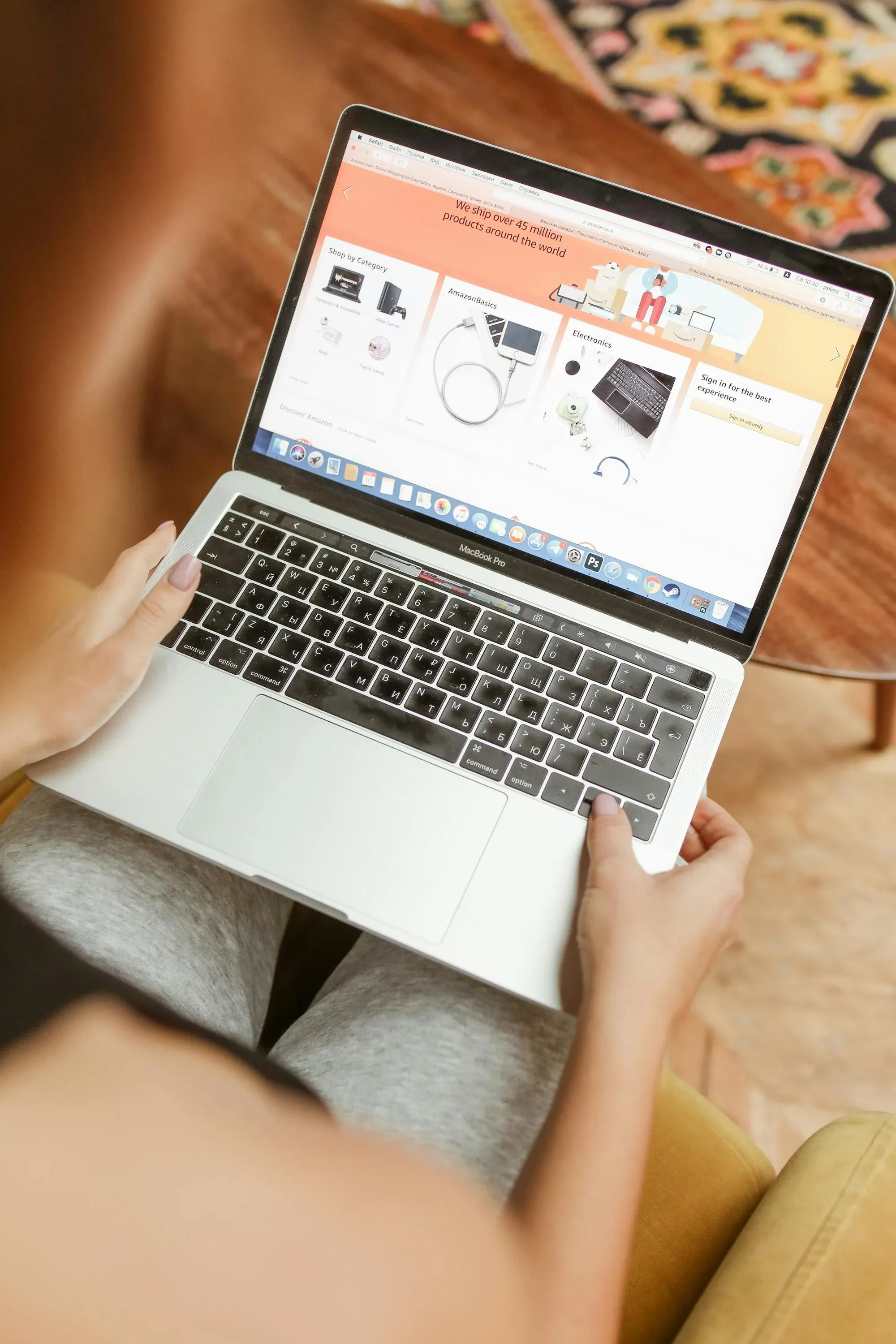 Picture of a person sitting with a laptop showing the Amazon retail website on their lap.