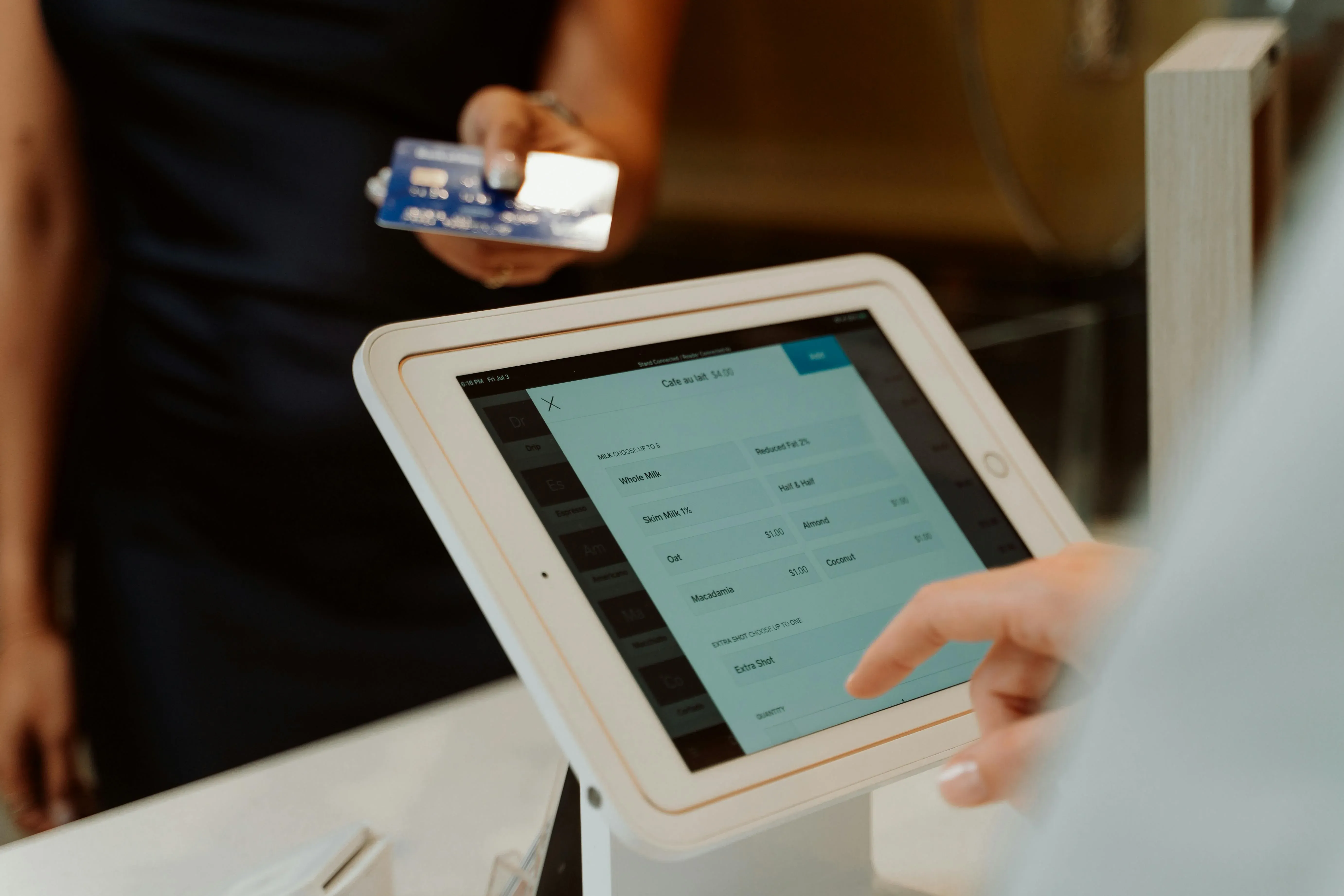 picture of a person selecting food items on a tablet point of sale interface